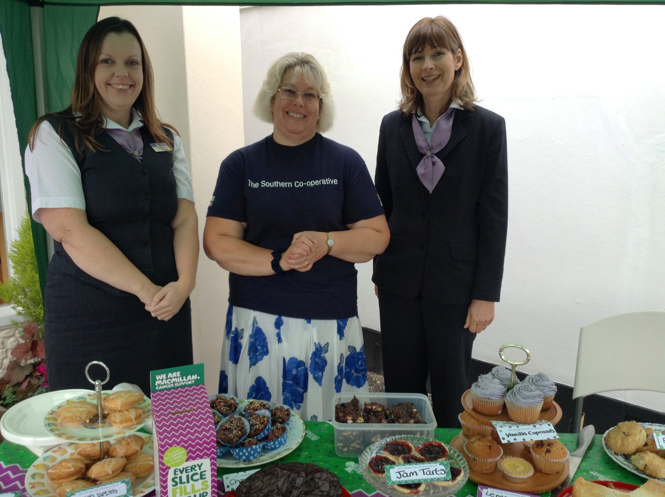 Image of The Southern Co-operative Funeralcare Co-ordinators (L-R) Shirley Heaton, Lindsey Booker and Julie Sells with a selection of home-made cakes as part of their Macmillan Coffee and Cake sale.
